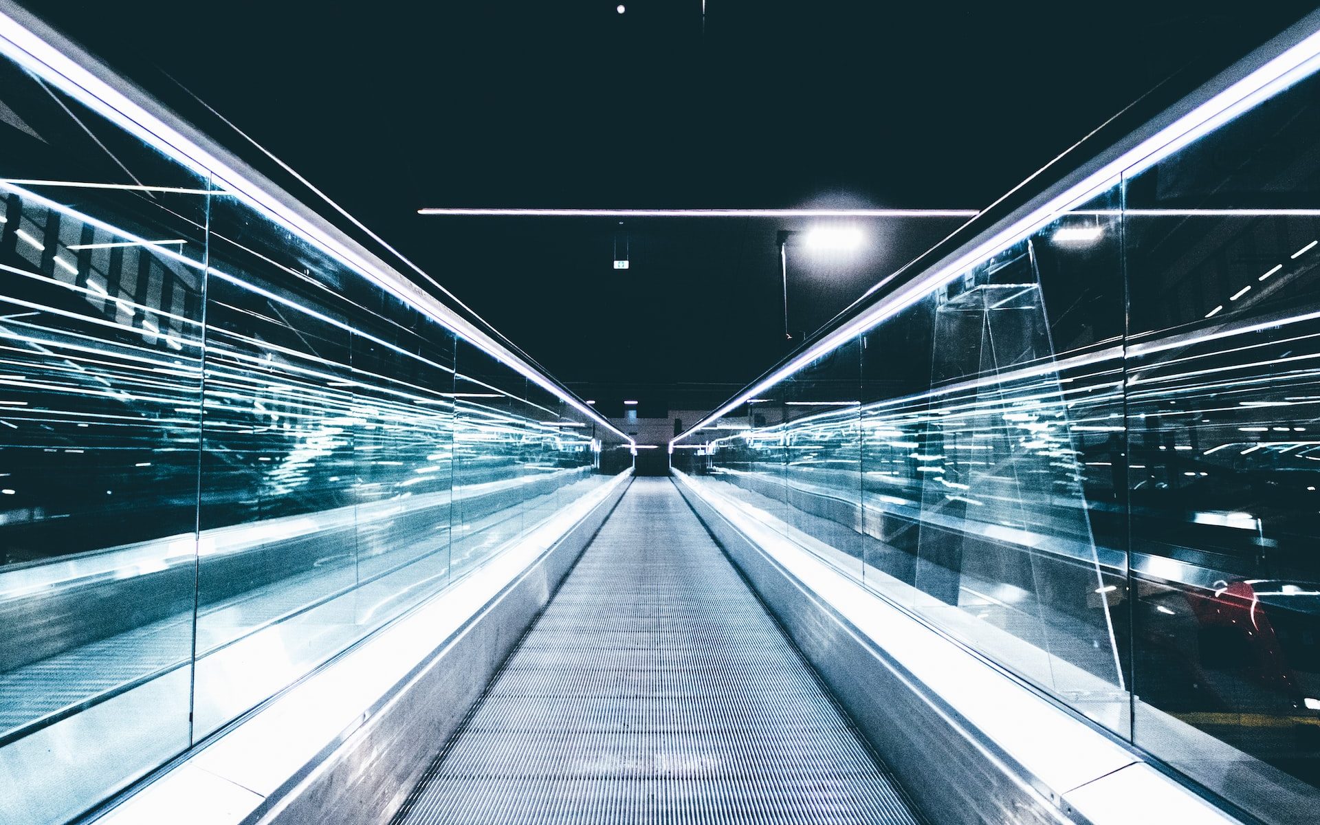 gray conveyor between glass frames at nighttime